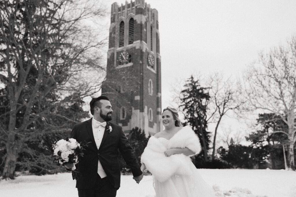 Kirsten and Jeff walk near Beaumont tower on Michigan State University's Campus on their wedding day