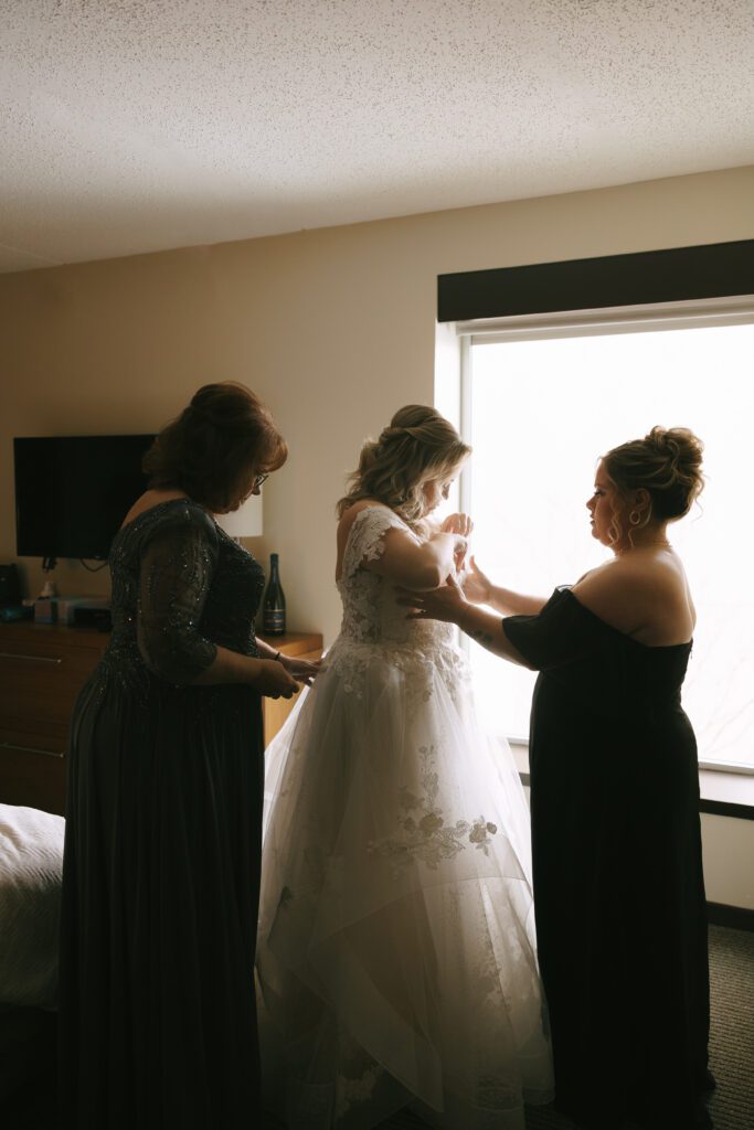 Kirsten getting into her wedding dress for her Michigan Wedding