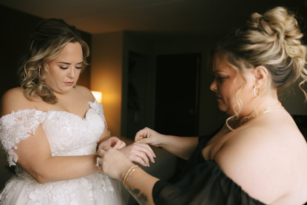 Maid of Honor Melanie putting Kirsten's bracelet on for her Michigan Wedding